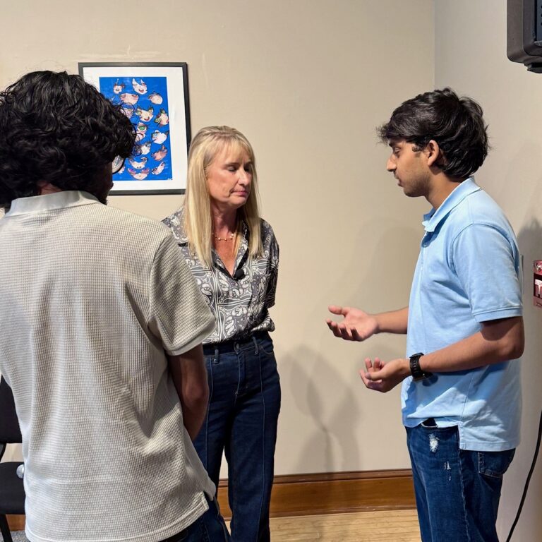 Blonde woman talking to students at a college