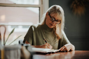 blonde woman writing in journal