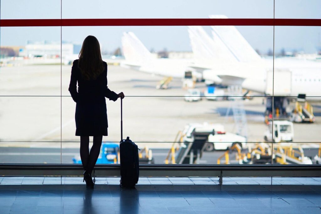 Young women in an airport looking out over the tarmac